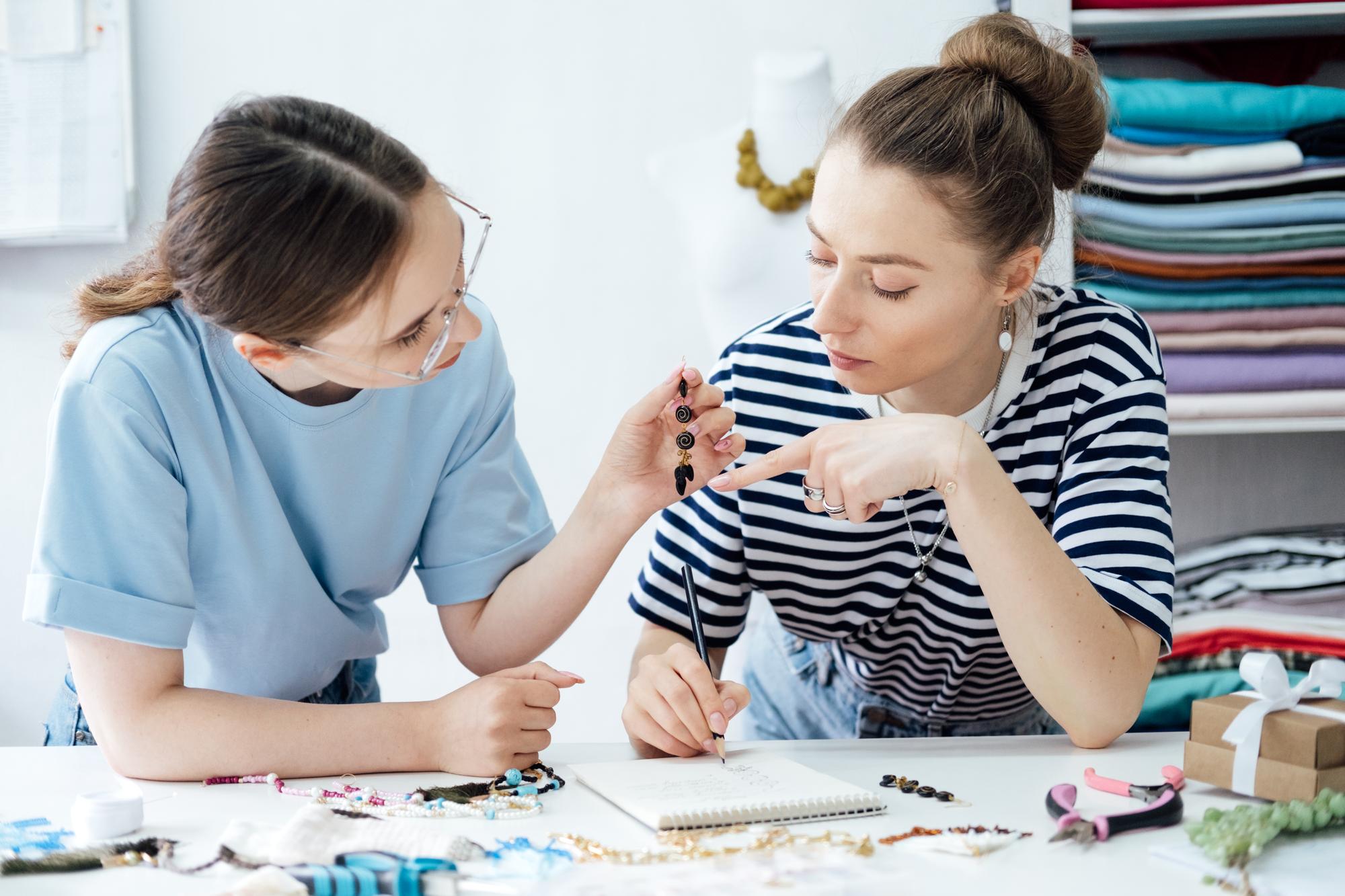 Instructor showing stitches to a student in a studio